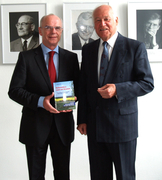 Harald Witt überreicht Präsident Christian Weber den Radwanderführer