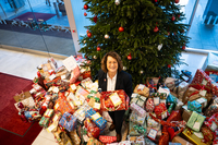 Antje Grotheer steht inmitten von Geschenken vor dem Wunschbaum der Bürgerschaft