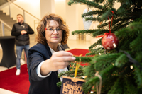 Antje Grotheer hängt einen Wunschzettel an den Weihnachtsbaum im Foyer der Bürgerschaft.